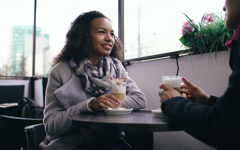 Two people meeting for coffee across a cafe table